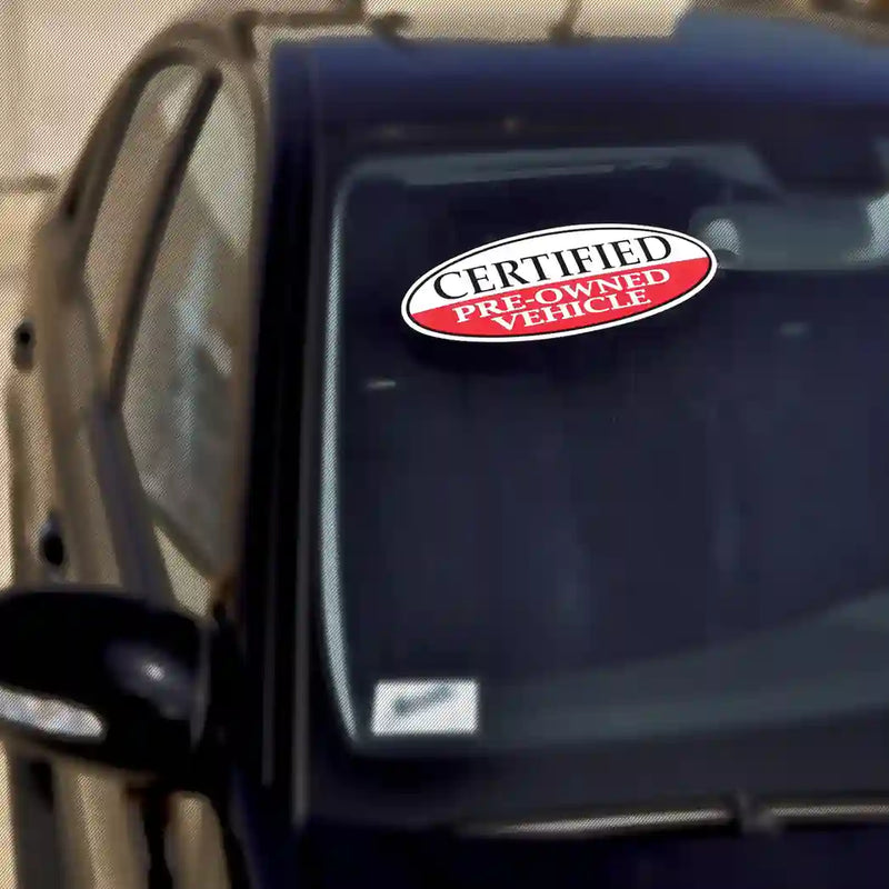 Certfied pre-owned stickers on car dealer lot.